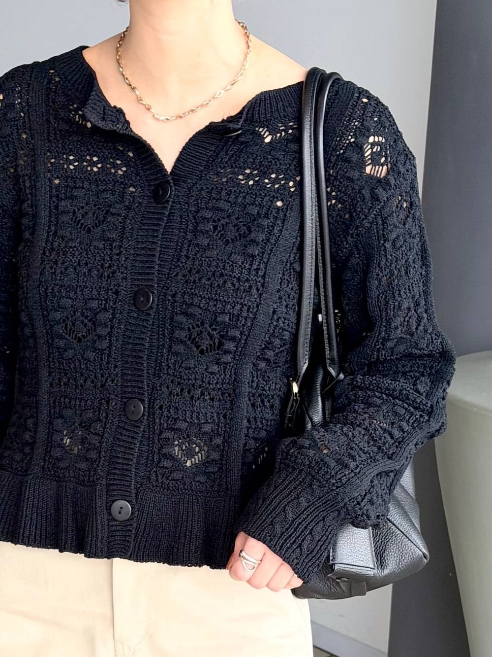 ブラック系のハンドバッグ、ブラック系のローファー、ブラック系のカーディガン/ボレロを着用したレディースの冬コーディネートの5枚目の写真