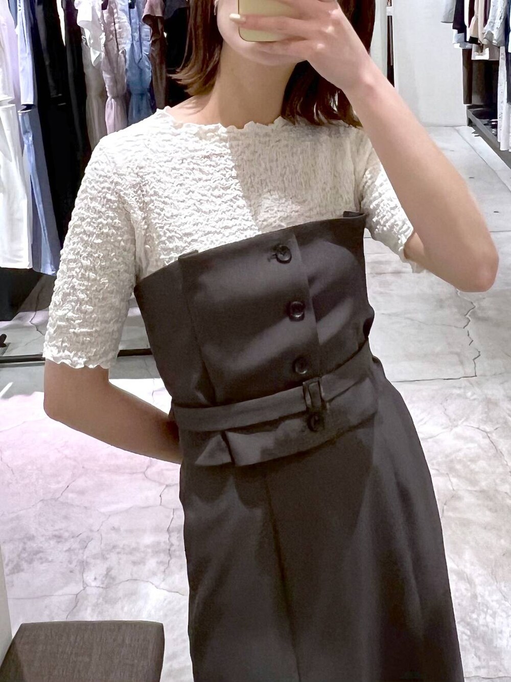 グレー系のスカート、ホワイト系のTシャツ/カットソー、ブラック系のショルダーバッグを着用したレディースの春コーディネートの6枚目の写真