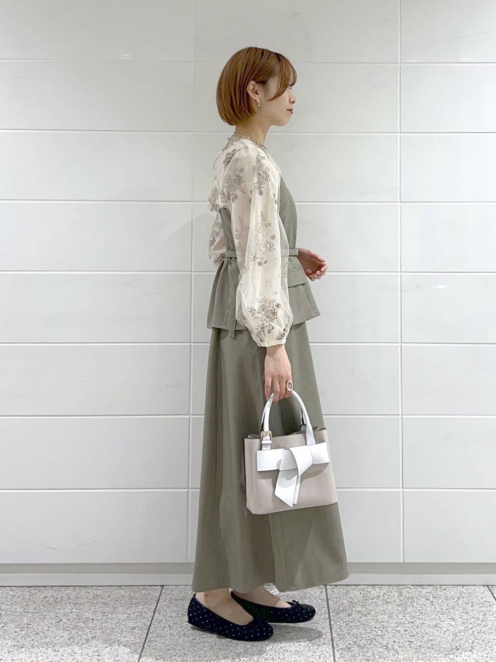 ベージュ系のショルダーバッグ、ブラック系のバレエシューズ、ホワイト系のシャツ/ブラウスを着用したレディースの春コーディネートの2枚目の写真