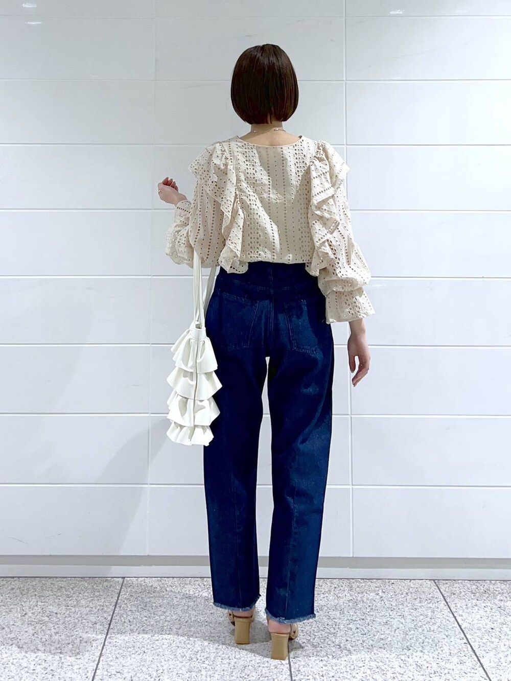 ホワイト系のシャツ/ブラウス、ベージュ系のパンプス、ホワイト系のトートバッグを着用したレディースの冬コーディネートの3枚目の写真