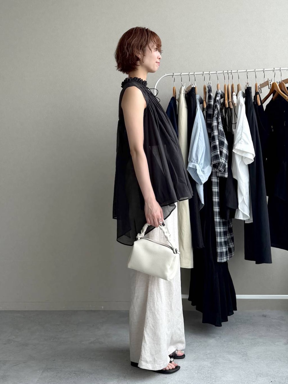 ブラック系のシャツ/ブラウス、ベージュ系のその他パンツ、ホワイト系のショルダーバッグを着用したレディースの夏コーディネートの2枚目の写真