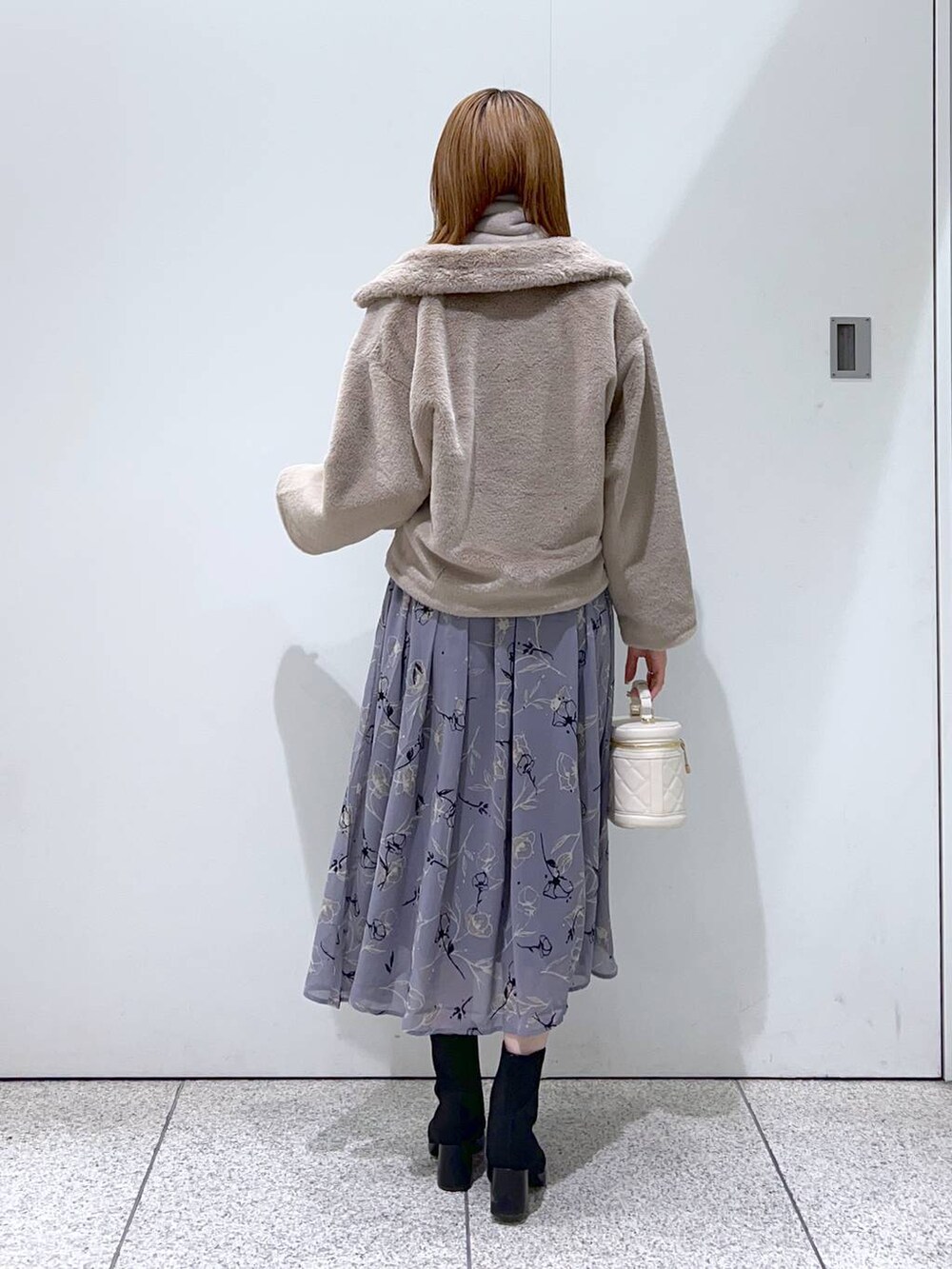 ブラック系のブーツ、ブルー系のワンピース、ホワイト系のショルダーバッグを着用したレディースの秋コーディネートの3枚目の写真