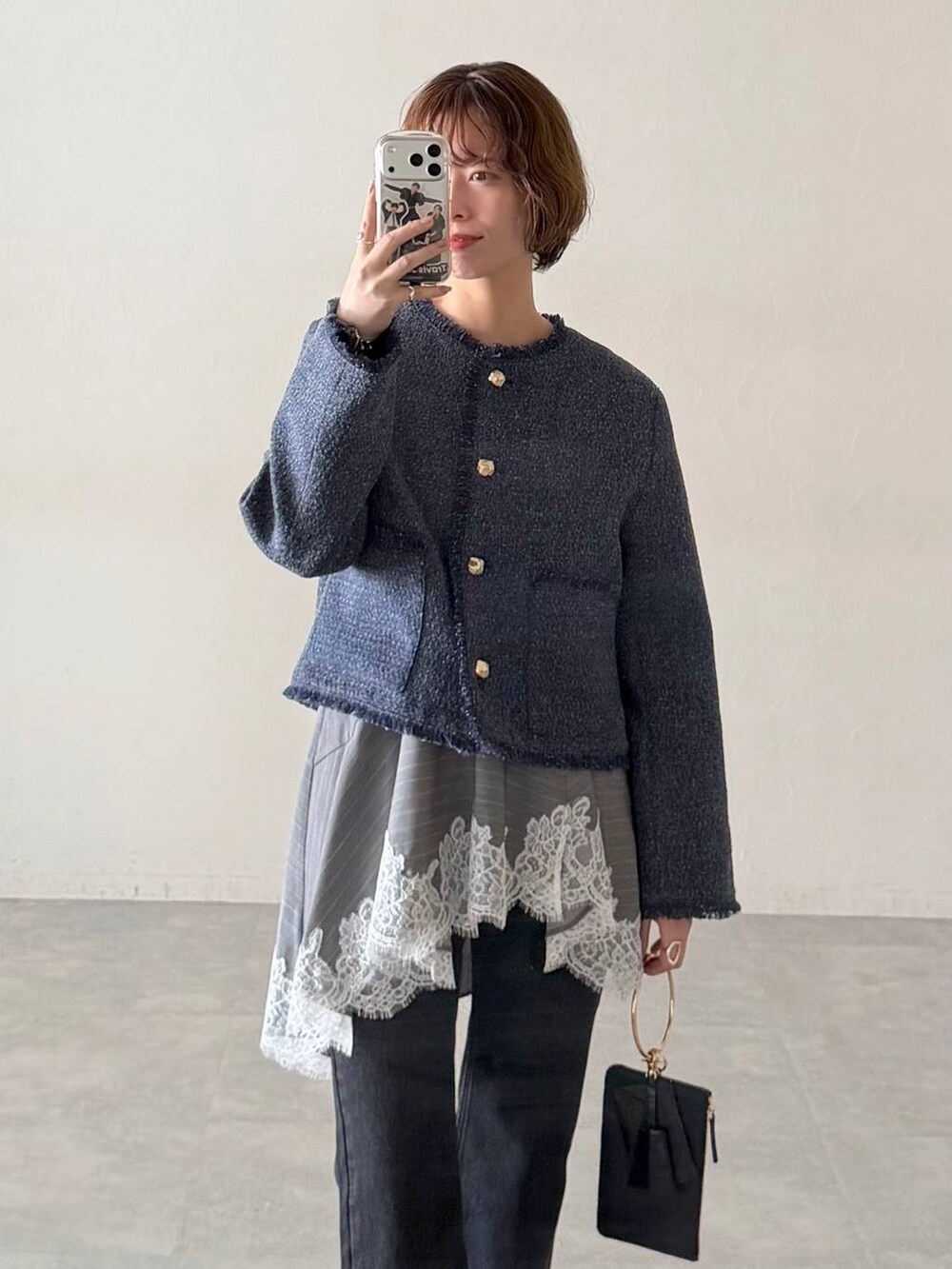 ブラック系のデニムパンツ、ブラック系のサンダル、ブラック系のショルダーバッグを着用したレディースの春コーディネートの4枚目の写真