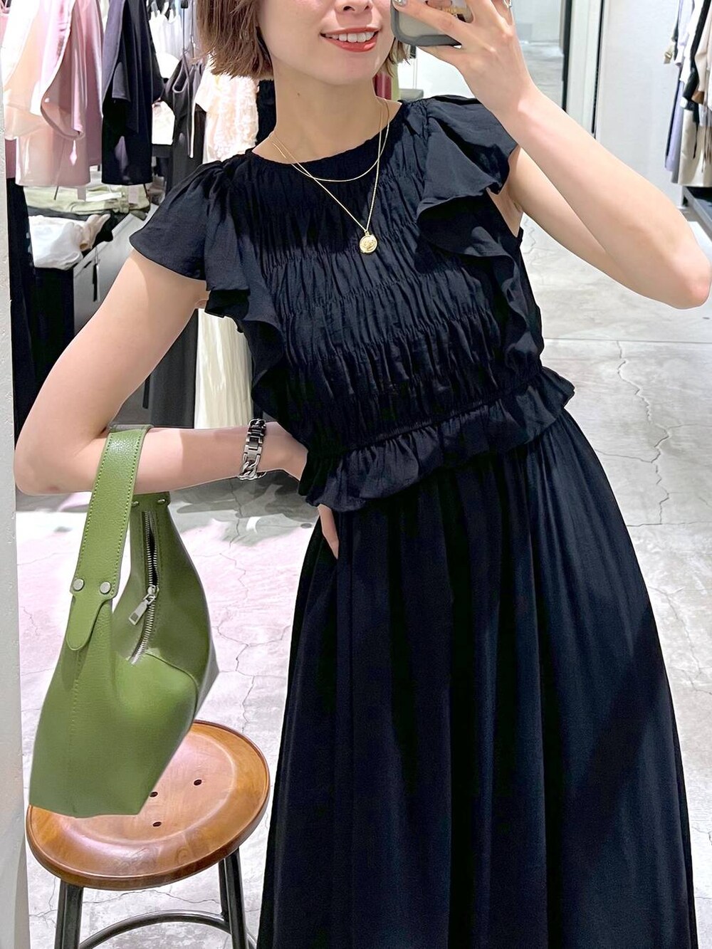 ベージュ系のサンダル、グリーン系のショルダーバッグ、ブラック系のワンピースを着用したレディースの夏コーディネートの4枚目の写真