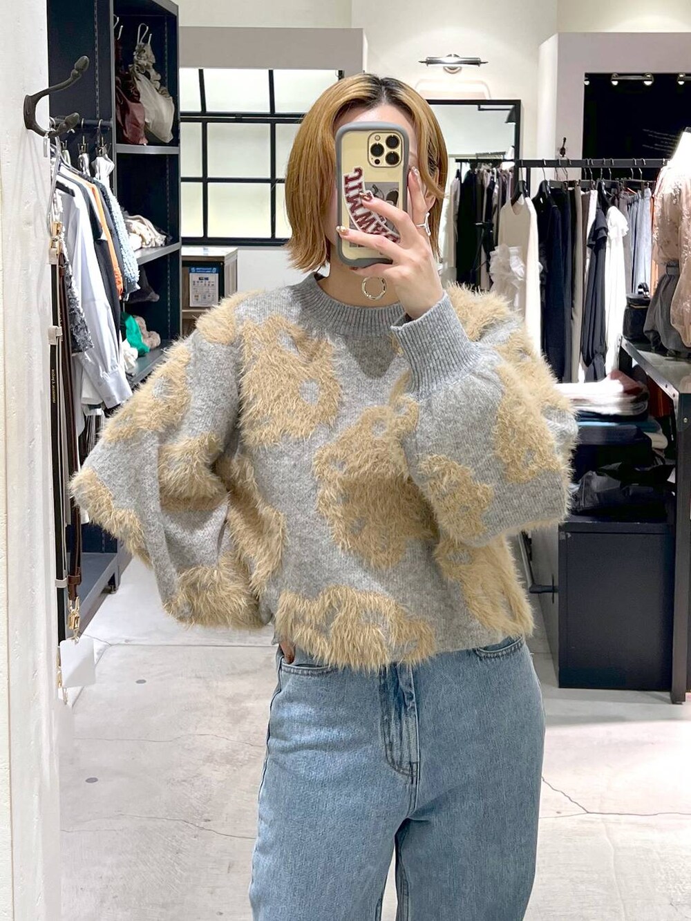 ブルー系のデニムパンツ、ブラック系のブーツ、ブラック系のショルダーバッグを着用したレディースの秋コーディネートの4枚目の写真