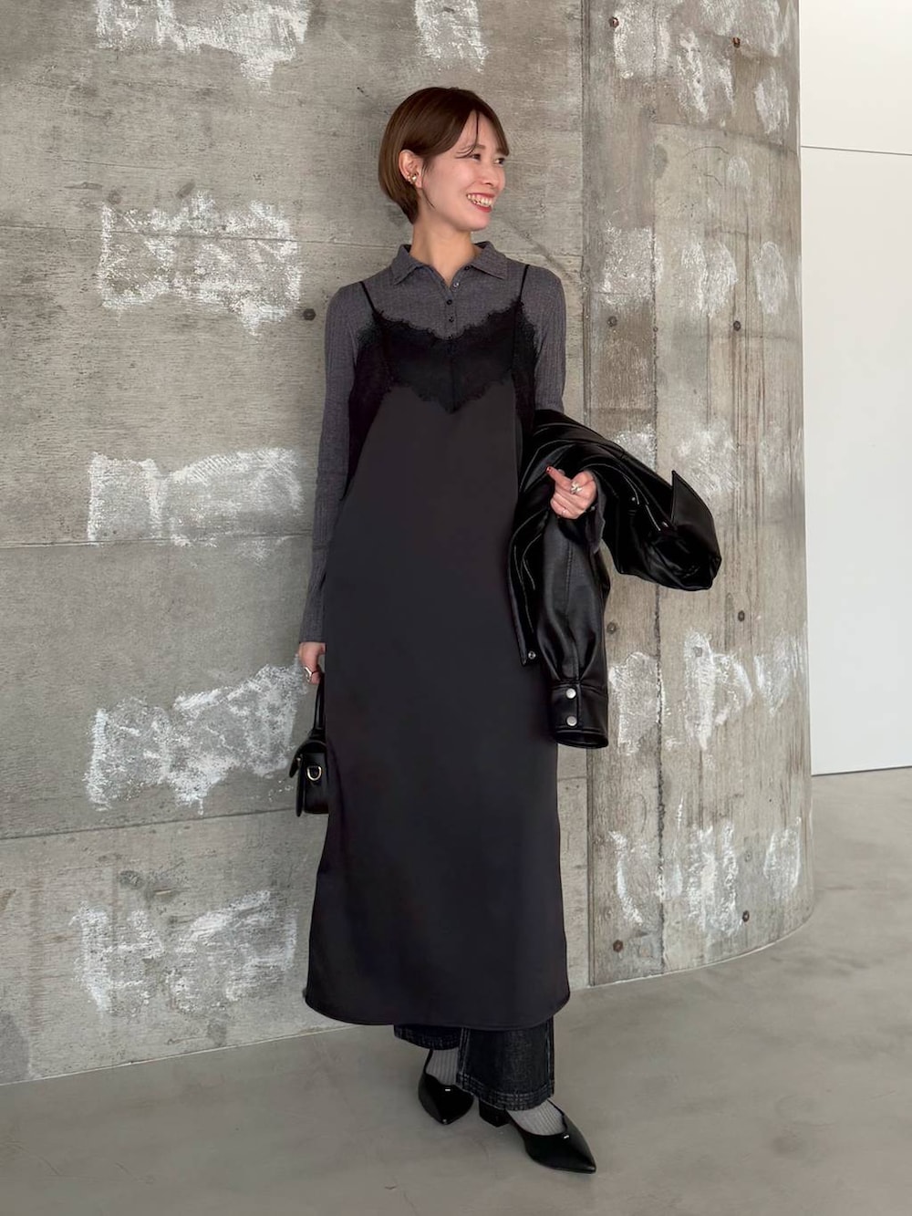 ブラック系のショルダーバッグ、ブラック系のデニムパンツ、ブラック系のパンプスを着用したレディースの冬コーディネートの6枚目の写真