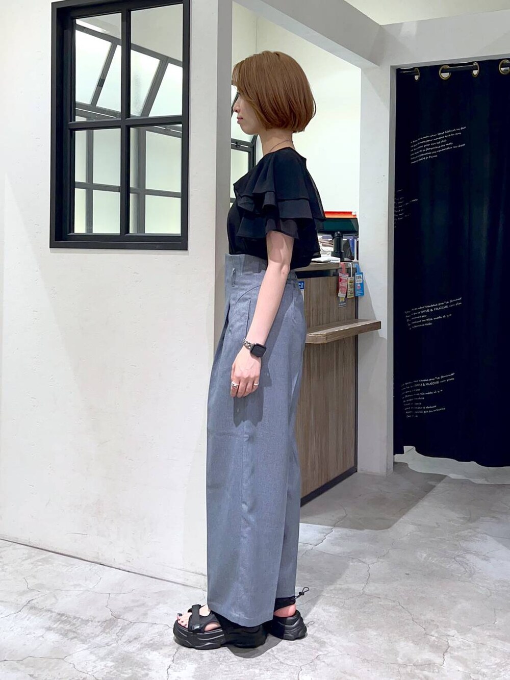 ブラック系のサンダル、ブラック系のショルダーバッグ、ブラック系のTシャツ/カットソーを着用したレディースの夏コーディネートの2枚目の写真