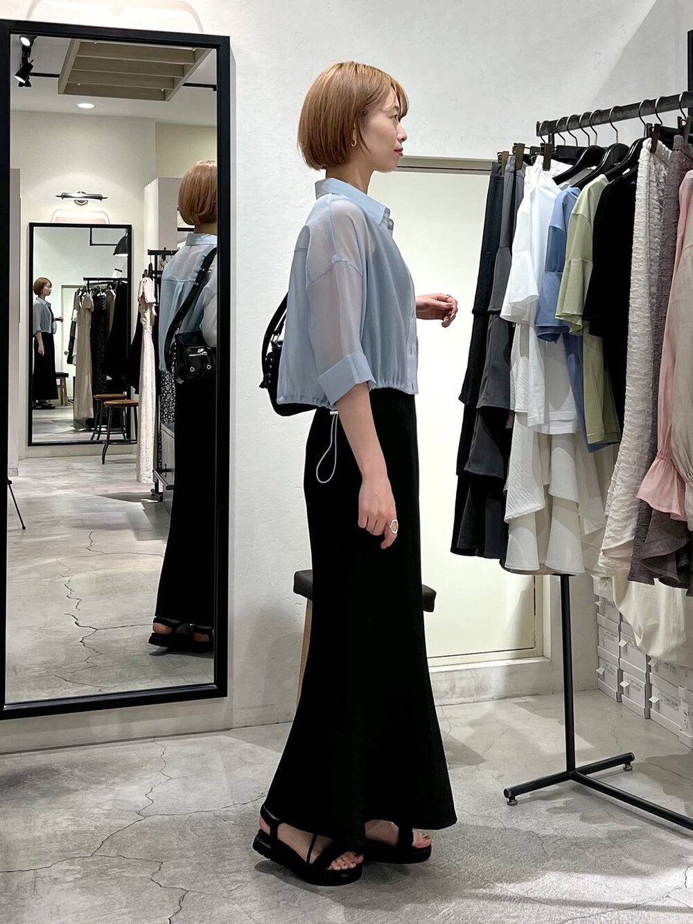 ブラック系のカーディガン/ボレロ、ブラック系のサンダル、ブラック系のスカートを着用したレディースの春コーディネートの2枚目の写真