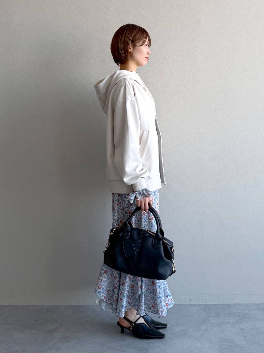 ブラック系のボストンバッグ、ホワイト系のパーカー、ブラック系のサンダルを着用したレディースの冬コーディネートの2枚目の写真