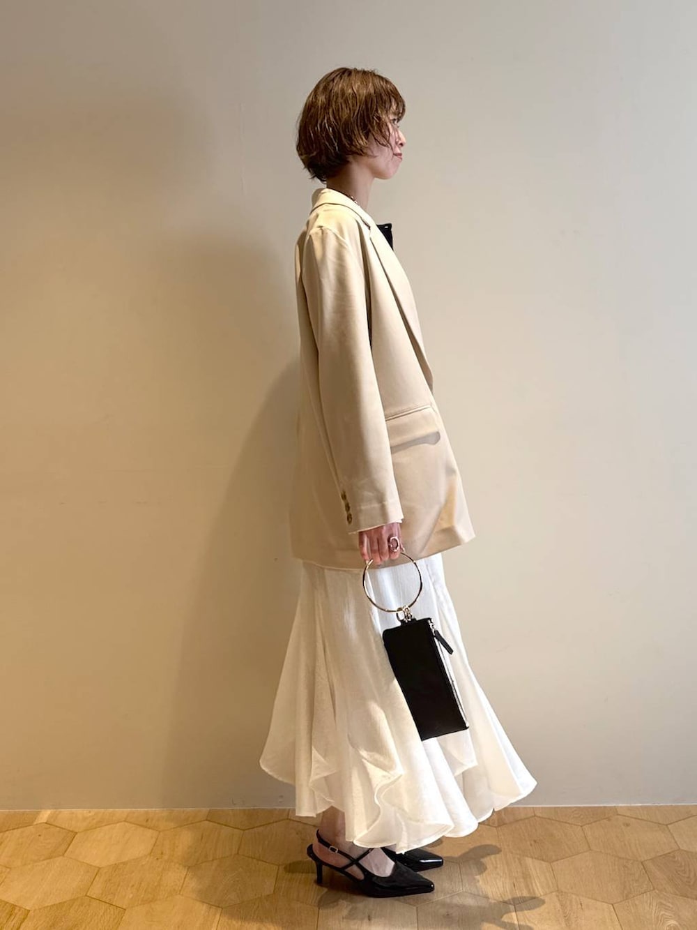 ブラック系のサンダル、ブラック系のショルダーバッグ、ブルー系のニット/セーターを着用したレディースの冬コーディネートの2枚目の写真