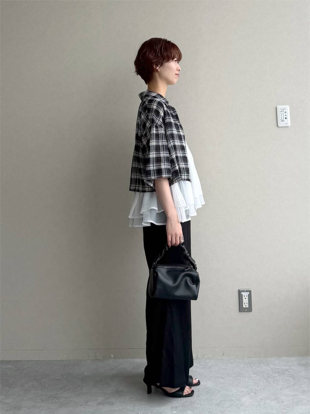 ブラック系のシャツ/ブラウス、ブルー系のニット/セーター、ブラック系のサンダルを着用したレディースの夏コーディネートの2枚目の写真