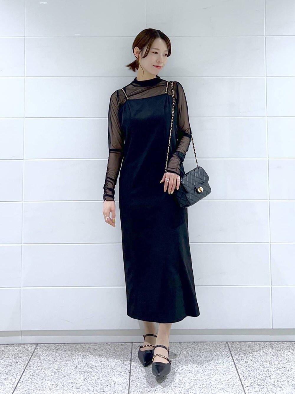 ブラック系のドレス、ブラック系のショルダーバッグ、ブラック系のパンプスを着用したレディースの春コーディネートの4枚目の写真