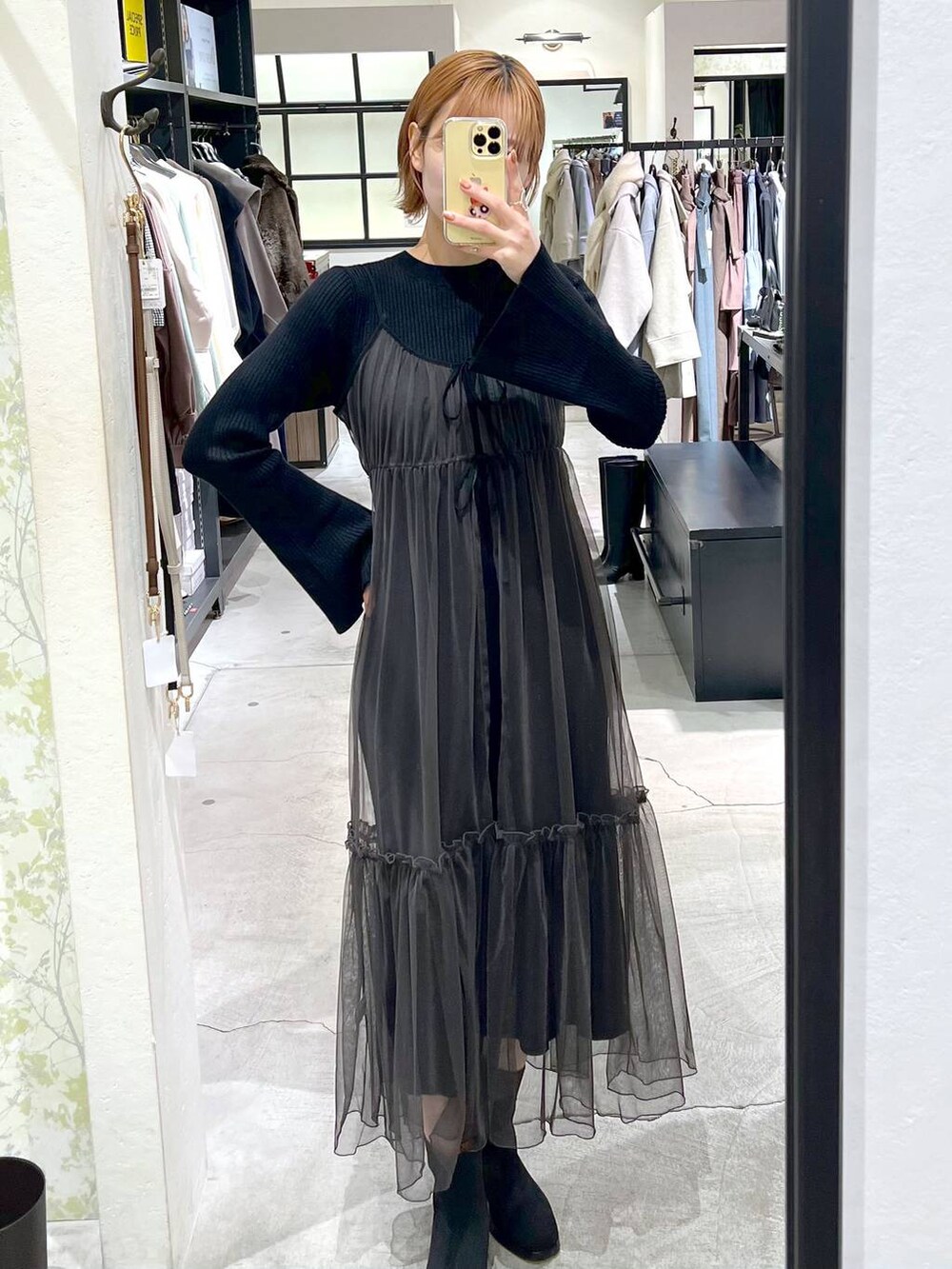 ブラック系のブーツ、ブラック系のハンドバッグ、グレー系のワンピースを着用したレディースの冬コーディネートの4枚目の写真