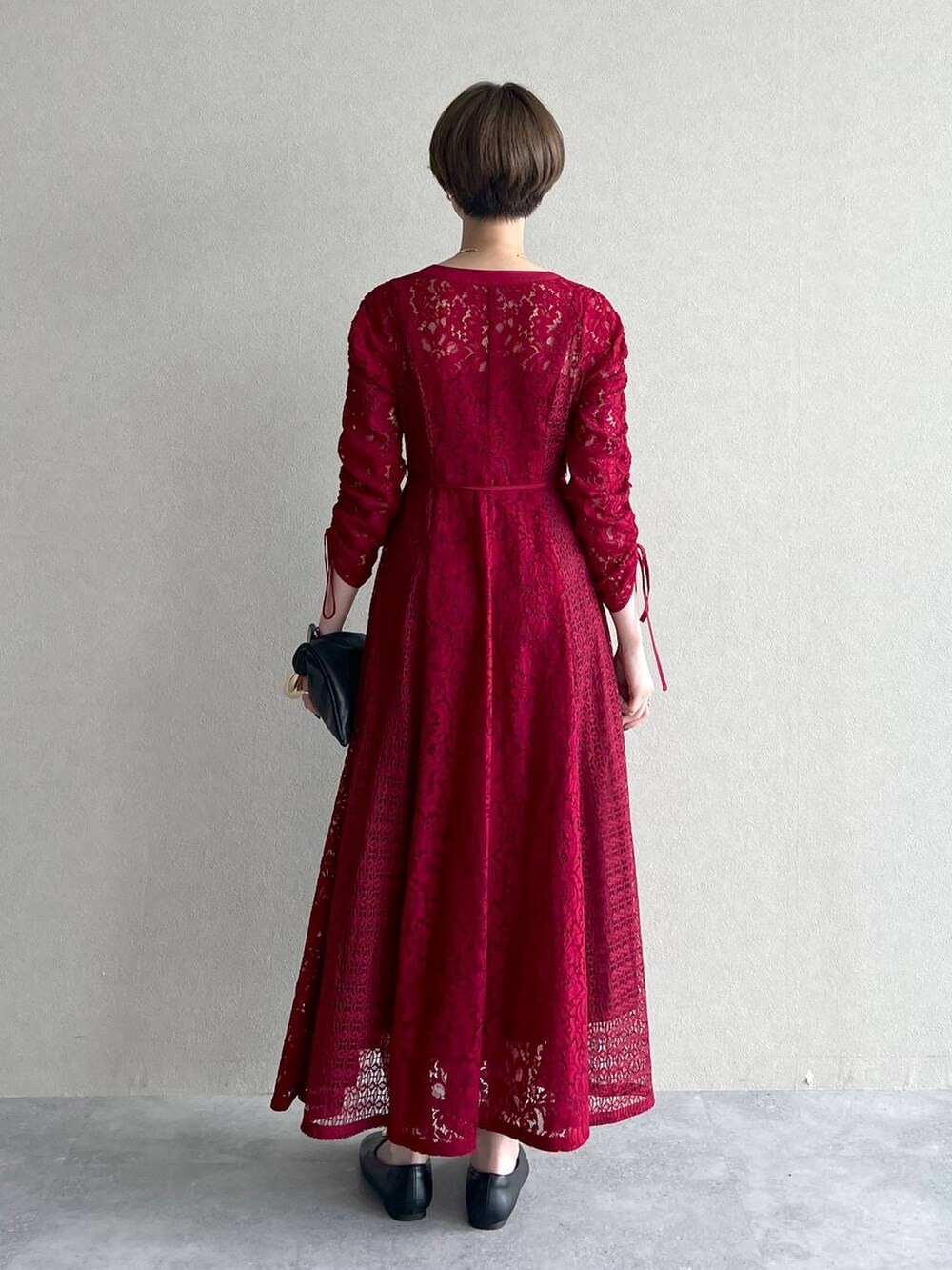 ブラック系のブルゾン、ブラック系のハンドバッグ、レッド系のワンピースを着用したレディースの秋コーディネートの7枚目の写真