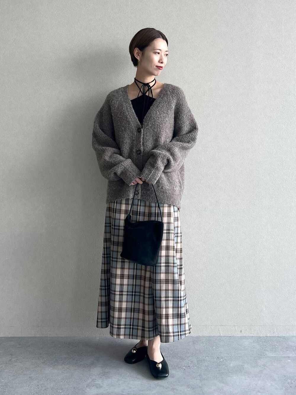 ベージュ系のカーディガン/ボレロ、ブラック系のバレエシューズ、ブラック系のキャミソールを着用したレディースの秋コーディネートの2枚目の写真