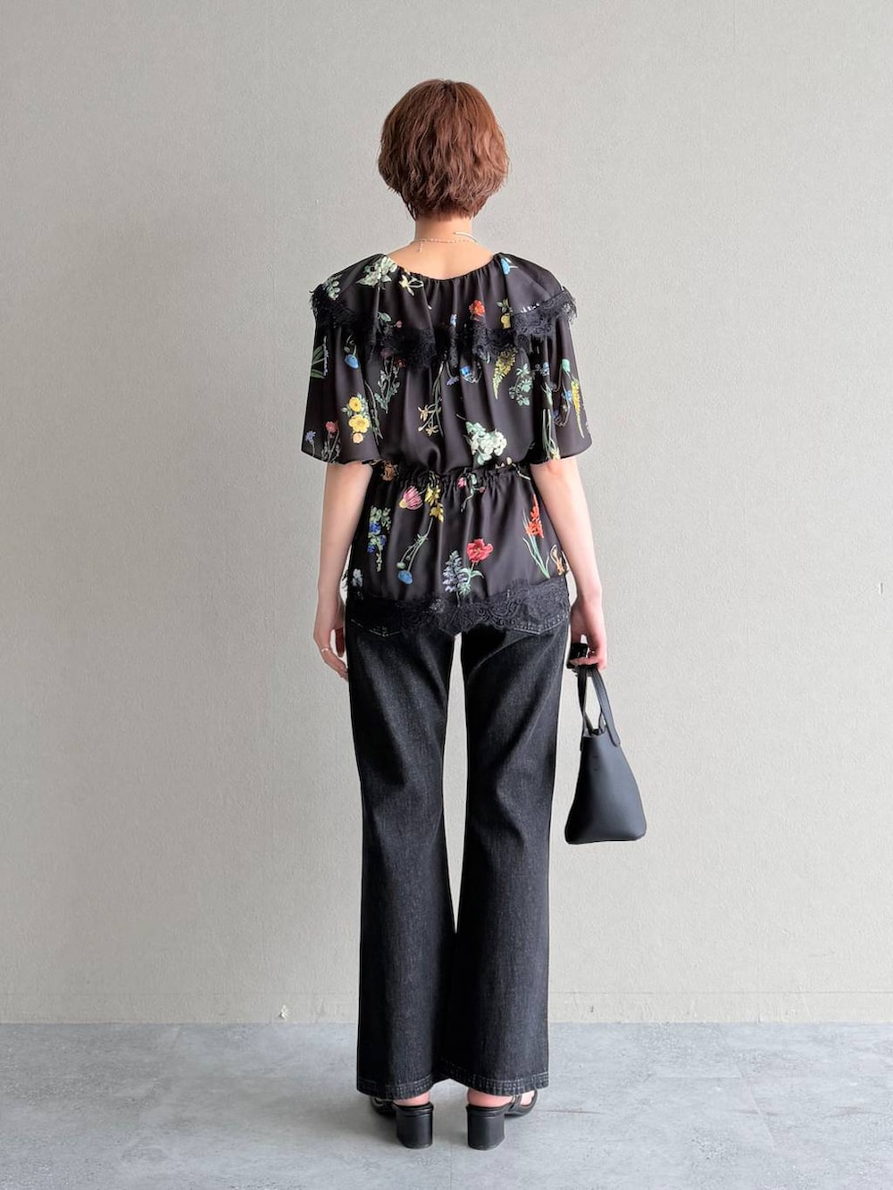 ブラック系のデニムパンツ、ブラック系のショルダーバッグ、ブラック系のシャツ/ブラウスを着用したレディースの春コーディネートの3枚目の写真