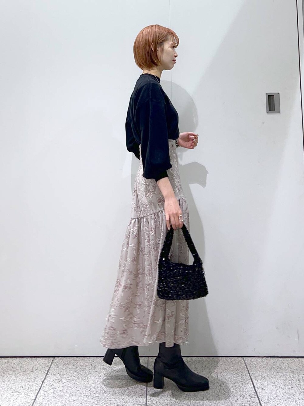 ブラック系のブーツ、ブラック系のニット/セーター、ブラック系のハンドバッグを着用したレディースの冬コーディネートの5枚目の写真