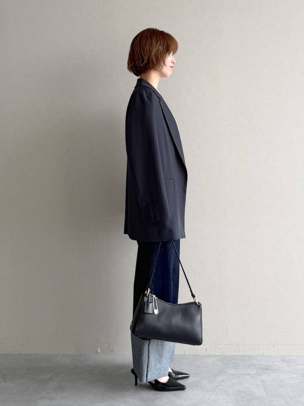 ブラック系のサンダル、ブルー系のシャツ/ブラウス、ブラック系のショルダーバッグを着用したレディースの春コーディネートの2枚目の写真