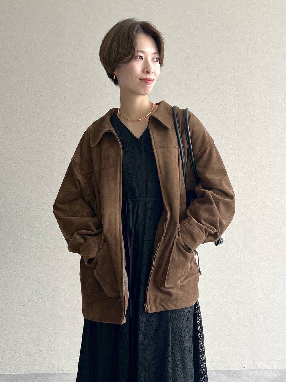 ブラック系のハンドバッグ、ブラック系のワンピース、ブラック系のドレスシューズを着用したレディースの秋コーディネートの4枚目の写真