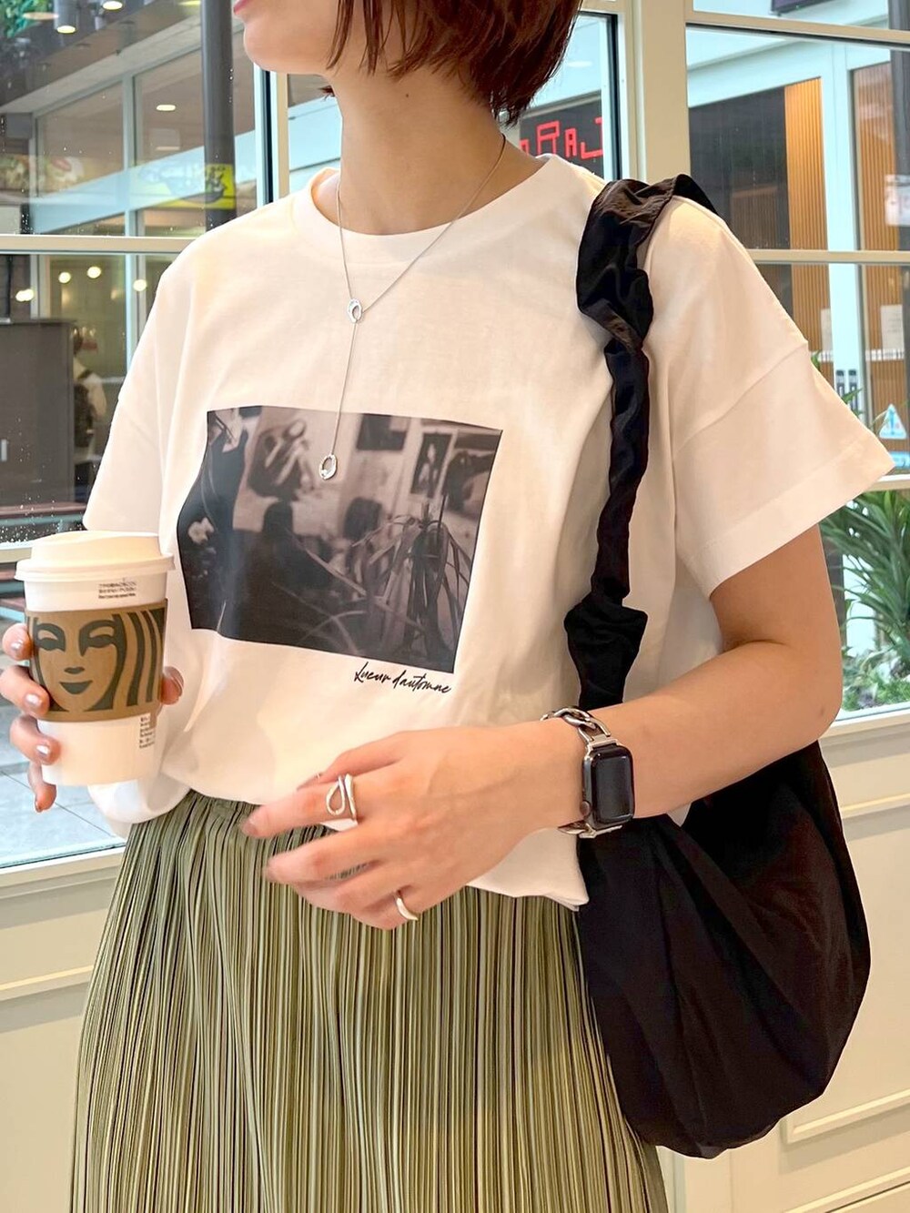 ブラック系のサンダル、ブラック系のショルダーバッグ、ホワイト系のTシャツ/カットソーを着用したレディースの夏コーディネートの3枚目の写真