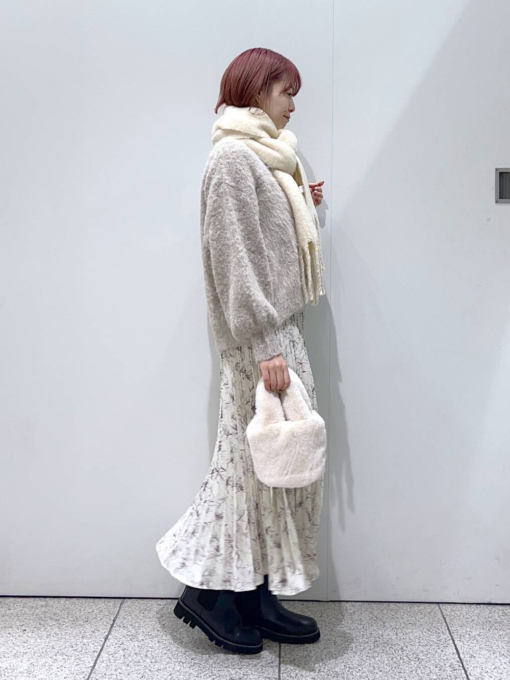 ブラック系のブーツ、ブラウン系のカーディガン/ボレロ、ホワイト系のTシャツ/カットソーを着用したレディースの秋コーディネートの2枚目の写真