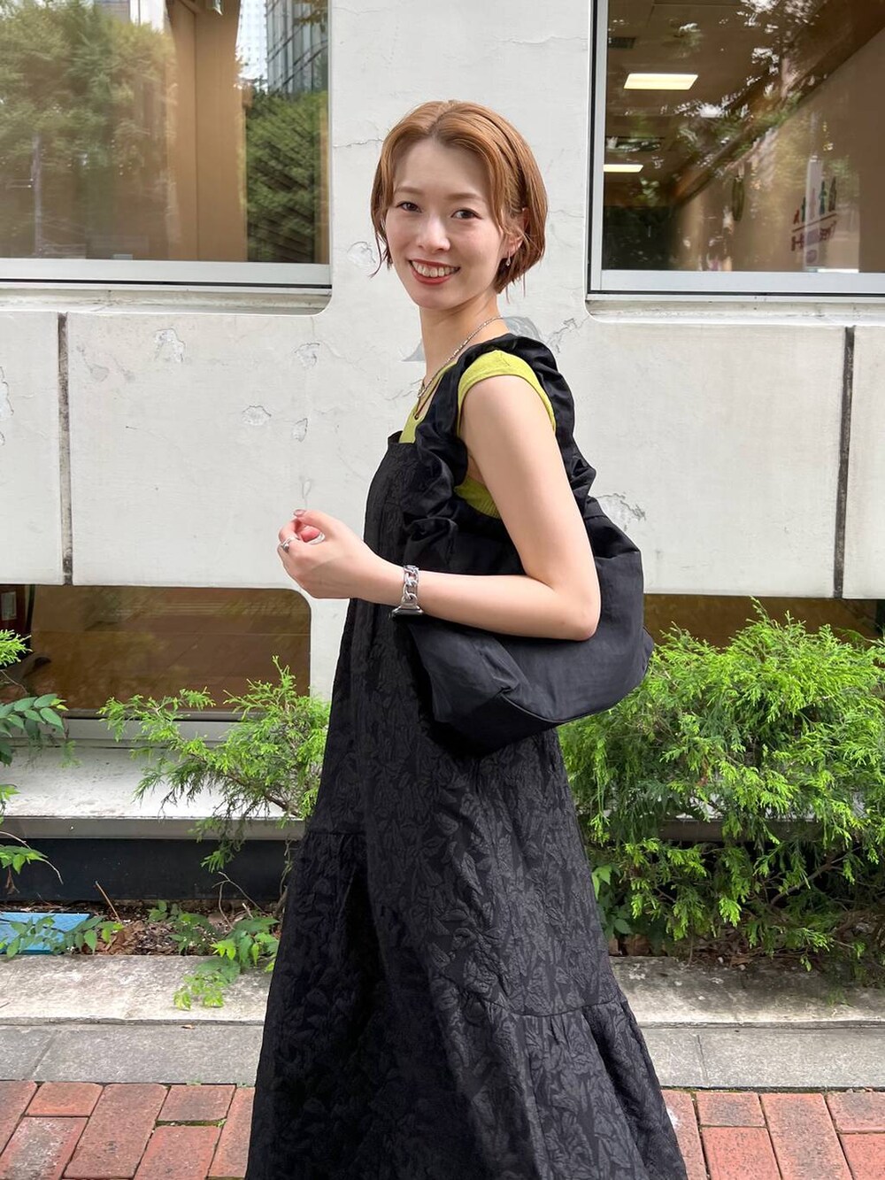 ブラック系のサンダル、グリーン系のニット/セーター、ブラック系のワンピースを着用したレディースの夏コーディネートの4枚目の写真