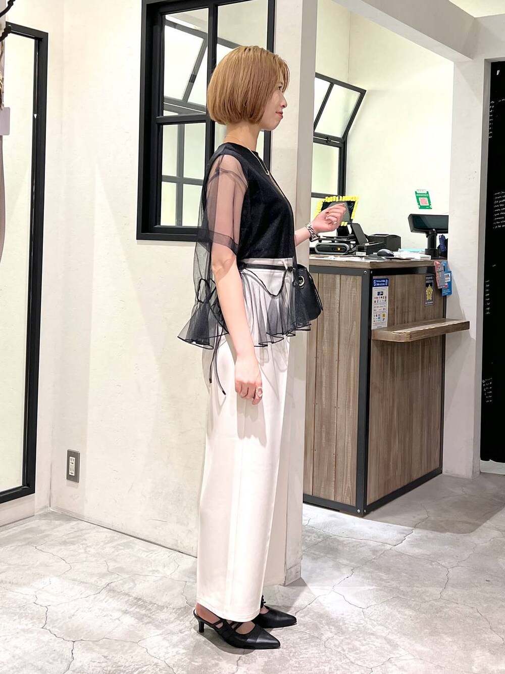 ブラック系のパンプス、ブラック系のショルダーバッグ、ブラック系のTシャツ/カットソーを着用したレディースの夏コーディネートの3枚目の写真