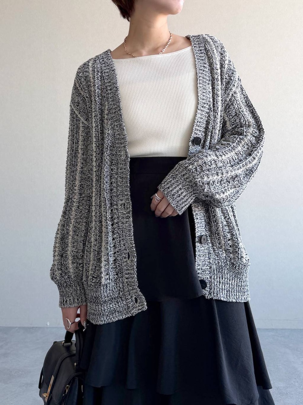 ブラック系のショルダーバッグ、ブラック系のサンダル、ホワイト系のニット/セーターを着用したレディースの冬コーディネートの4枚目の写真