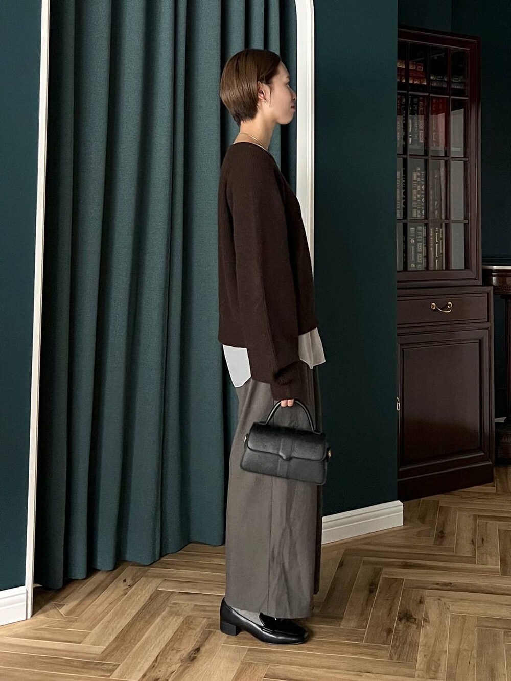 ブラウン系のニット/セーター、ブラック系のローファー、ホワイト系のTシャツ/カットソーを着用したレディースの秋コーディネートの2枚目の写真