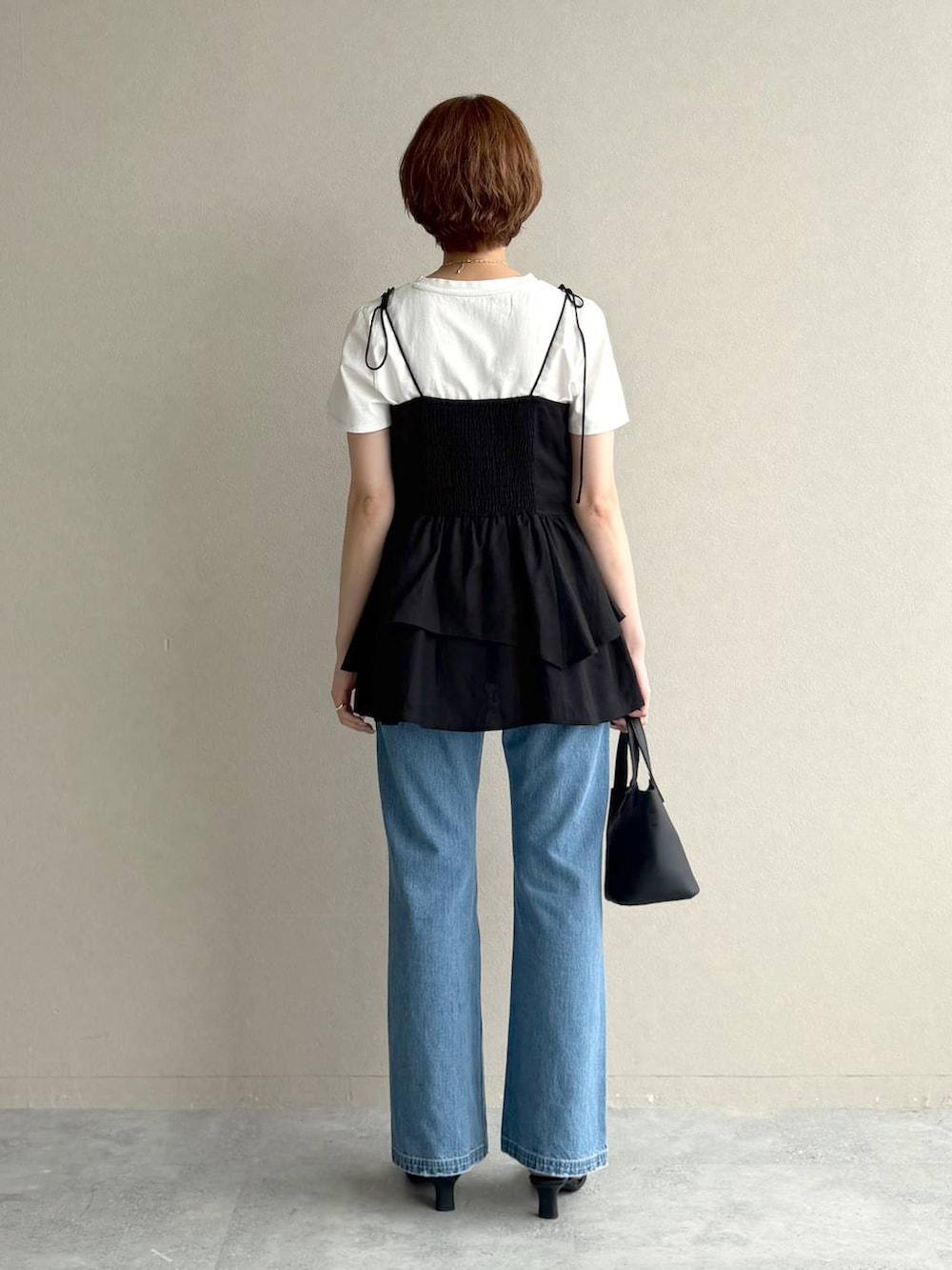 ブルー系のデニムパンツ、ブラック系のサンダル、ブラック系のシャツ/ブラウスを着用したレディースの夏コーディネートの3枚目の写真