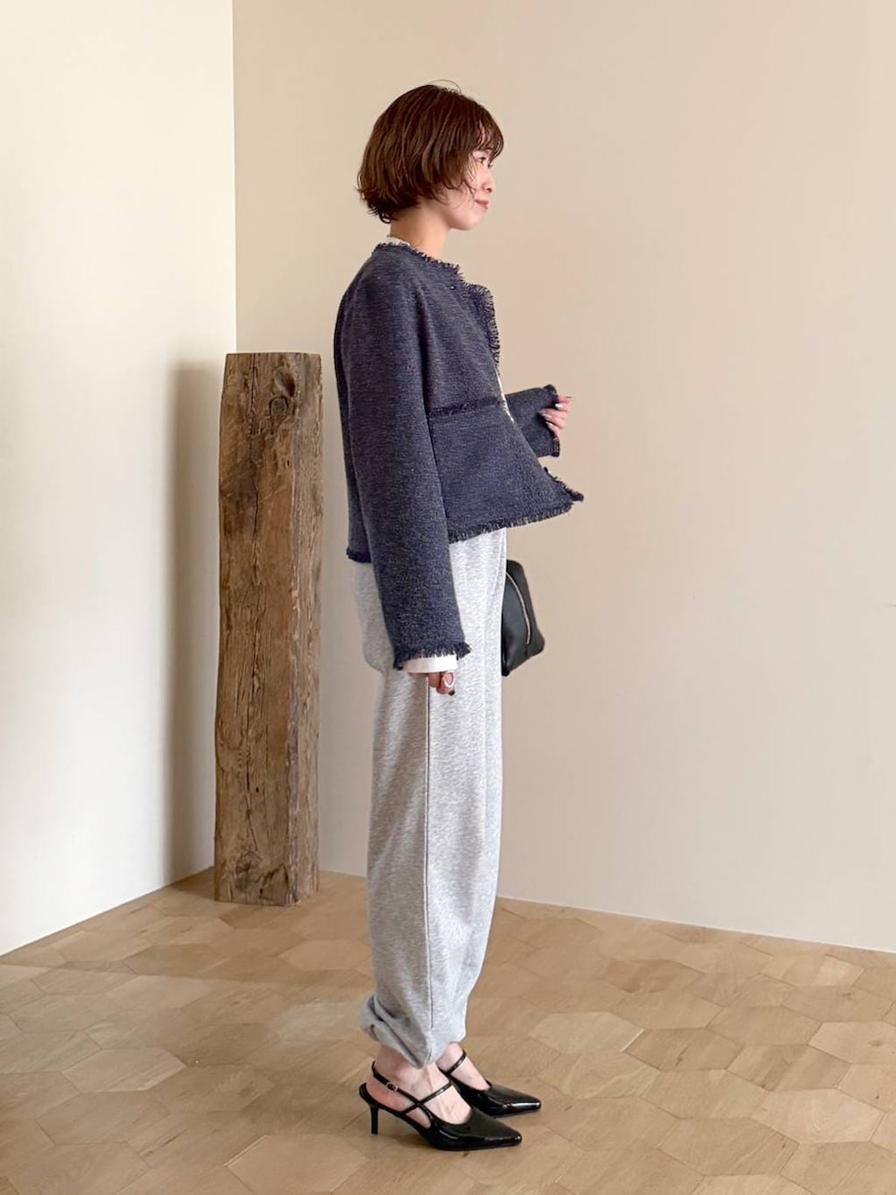 ブラック系のハンドバッグ、ブラック系のサンダル、ホワイト系のTシャツ/カットソーを着用したレディースの冬コーディネートの2枚目の写真