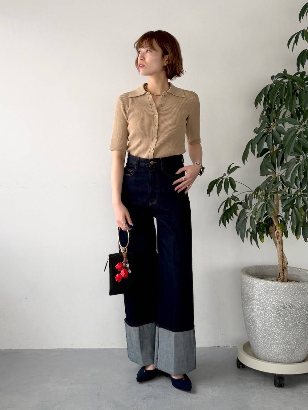 ブルー系のパンプス、ブラック系のショルダーバッグ、ブルー系のデニムパンツを着用したレディースの春コーディネートの5枚目の写真