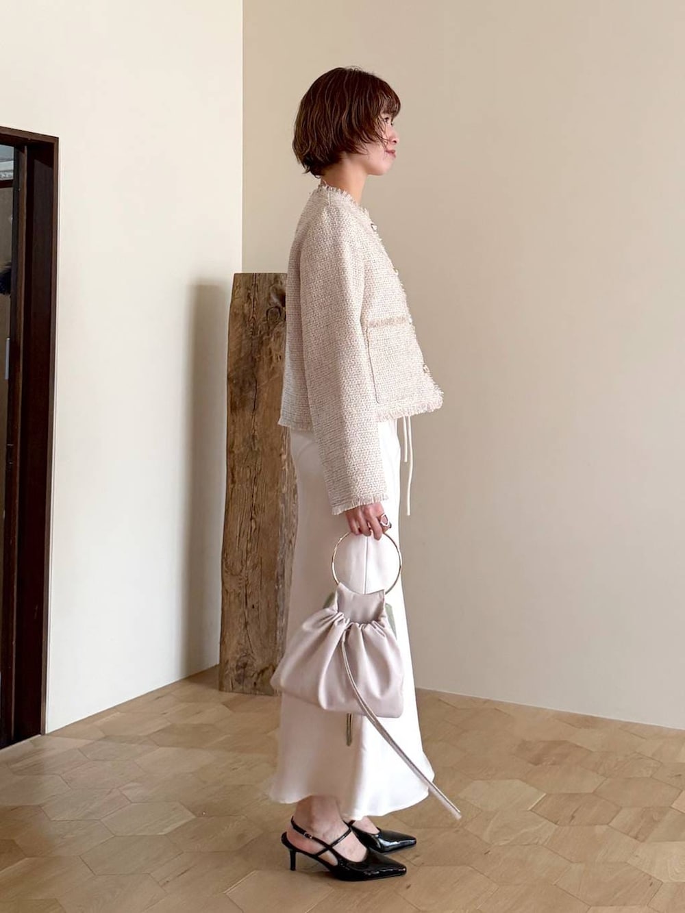 ブラック系のサンダル、ホワイト系のノーカラージャケット、ホワイト系のスカートを着用したレディースの冬コーディネートの2枚目の写真