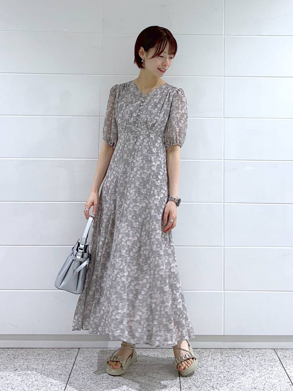 グレー系のサンダル、グレー系のワンピース、シルバー系のショルダーバッグを着用したレディースの夏コーディネートの2枚目の写真