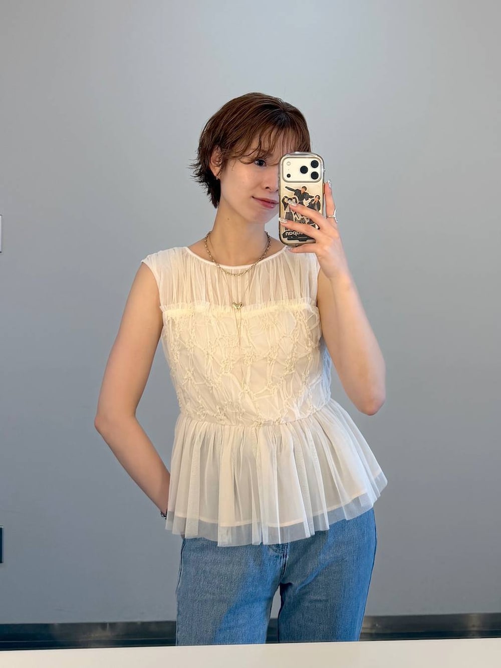 ブラック系のハンドバッグ、ブルー系のデニムパンツを着用したレディースの夏コーディネートの7枚目の写真