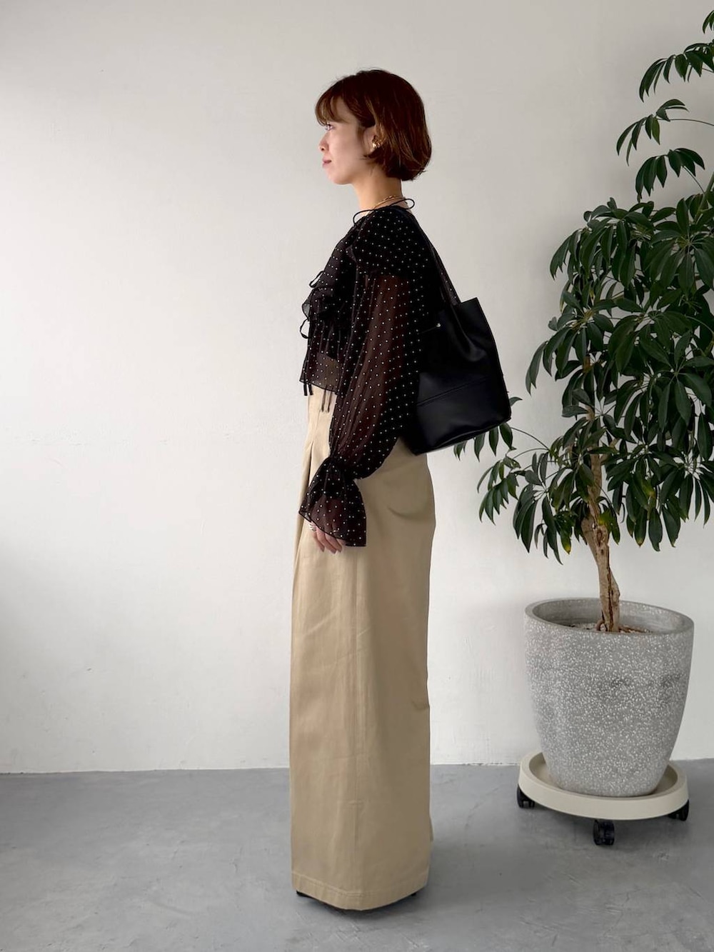 ブラック系のサンダル、ブラック系のシャツ/ブラウス、ベージュ系のチノパンツを着用したレディースの春コーディネートの2枚目の写真