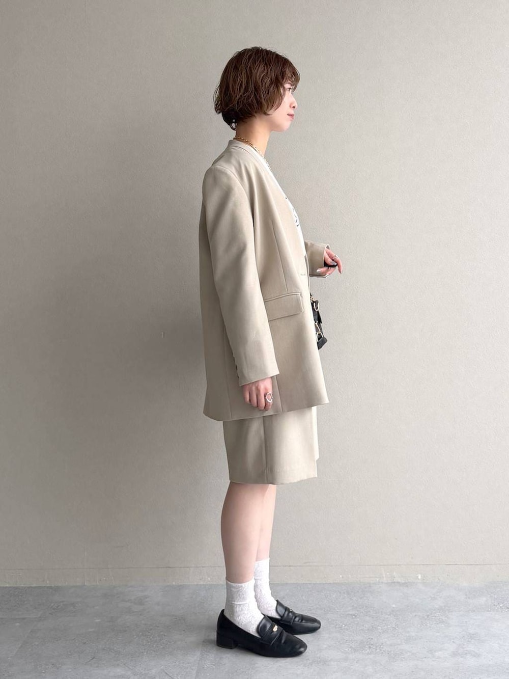 ブラック系のボストンバッグ、ブラック系のローファー、ベージュ系のその他パンツを着用したレディースの冬コーディネートの2枚目の写真