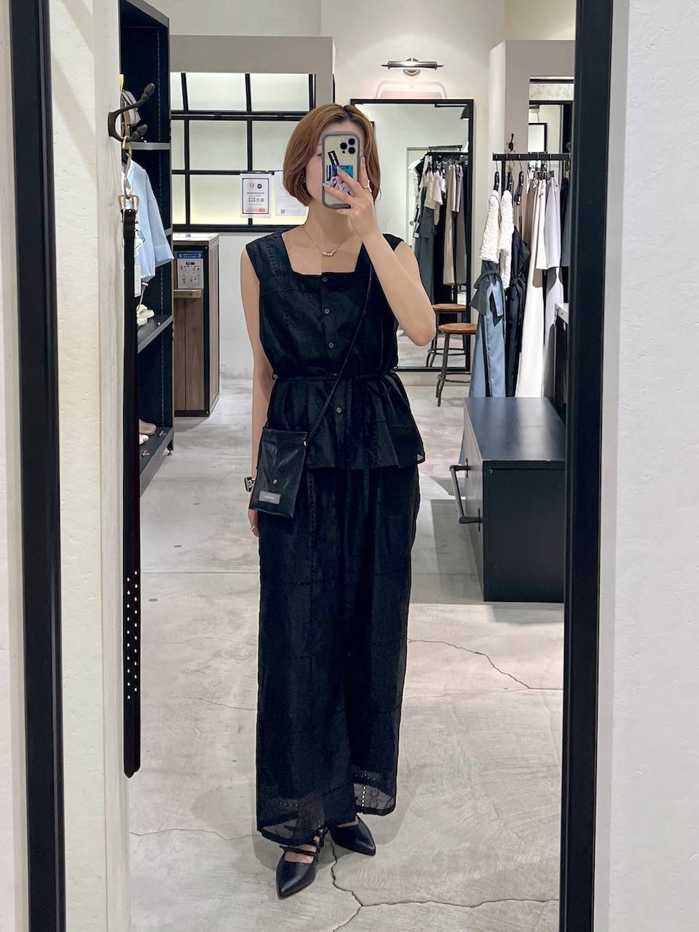 ブラック系のパンプス、ホワイト系のショルダーバッグ、ブラック系のシャツ/ブラウスを着用したレディースの夏コーディネートの4枚目の写真