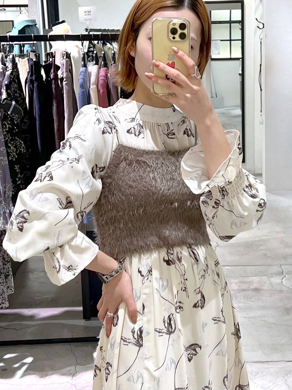 ホワイト系のショルダーバッグ、ブラック系のブーツ、ホワイト系のチェスターコートを着用したレディースの冬コーディネートの7枚目の写真