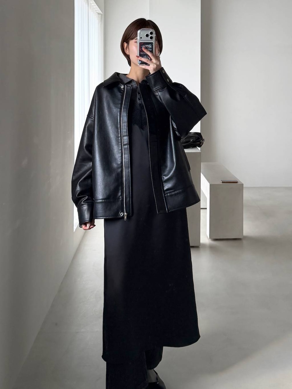 ブラック系のショルダーバッグ、ブラック系のデニムパンツ、ブラック系のパンプスを着用したレディースの冬コーディネートの8枚目の写真