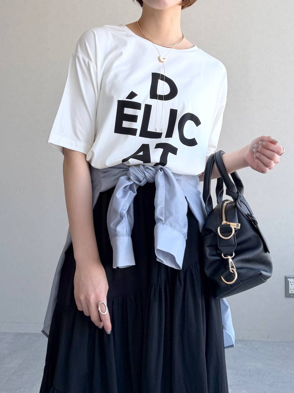 ブラック系のボストンバッグ、ブルー系のシャツ/ブラウス、ブラック系のサンダルを着用したレディースの春コーディネートの4枚目の写真