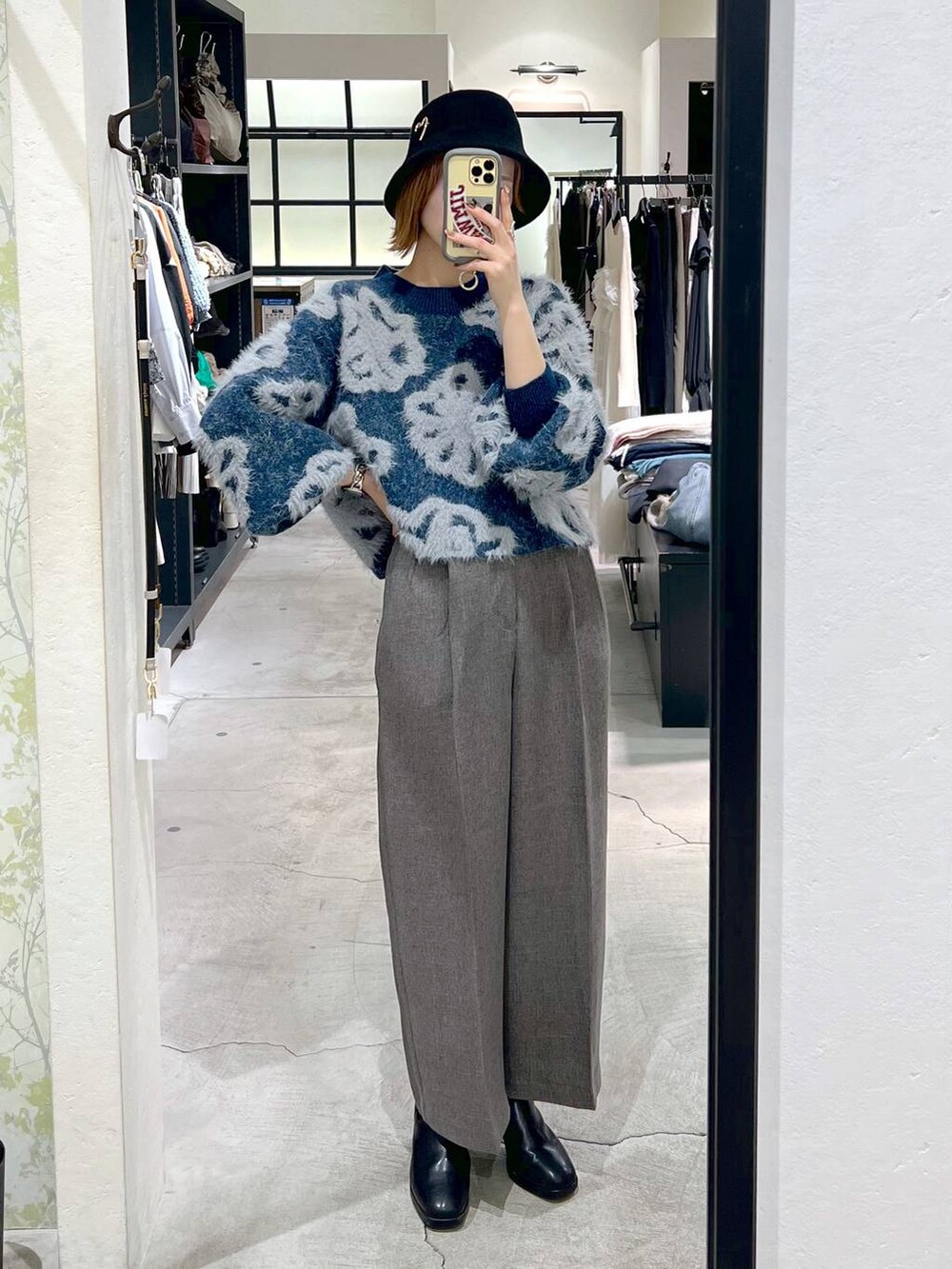 ブルー系のニット/セーター、ブラック系のショルダーバッグ、ブラック系のブーツを着用したレディースの秋コーディネートの5枚目の写真