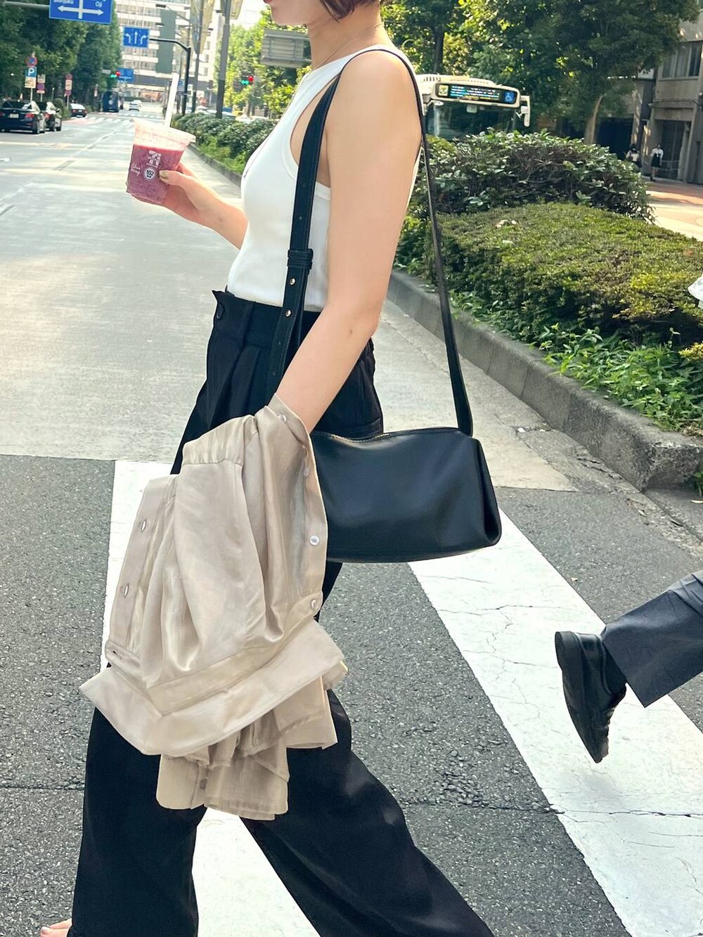 ブラック系のサンダル、ブラック系のスラックス、ブラック系のショルダーバッグを着用したレディースの夏コーディネートの3枚目の写真