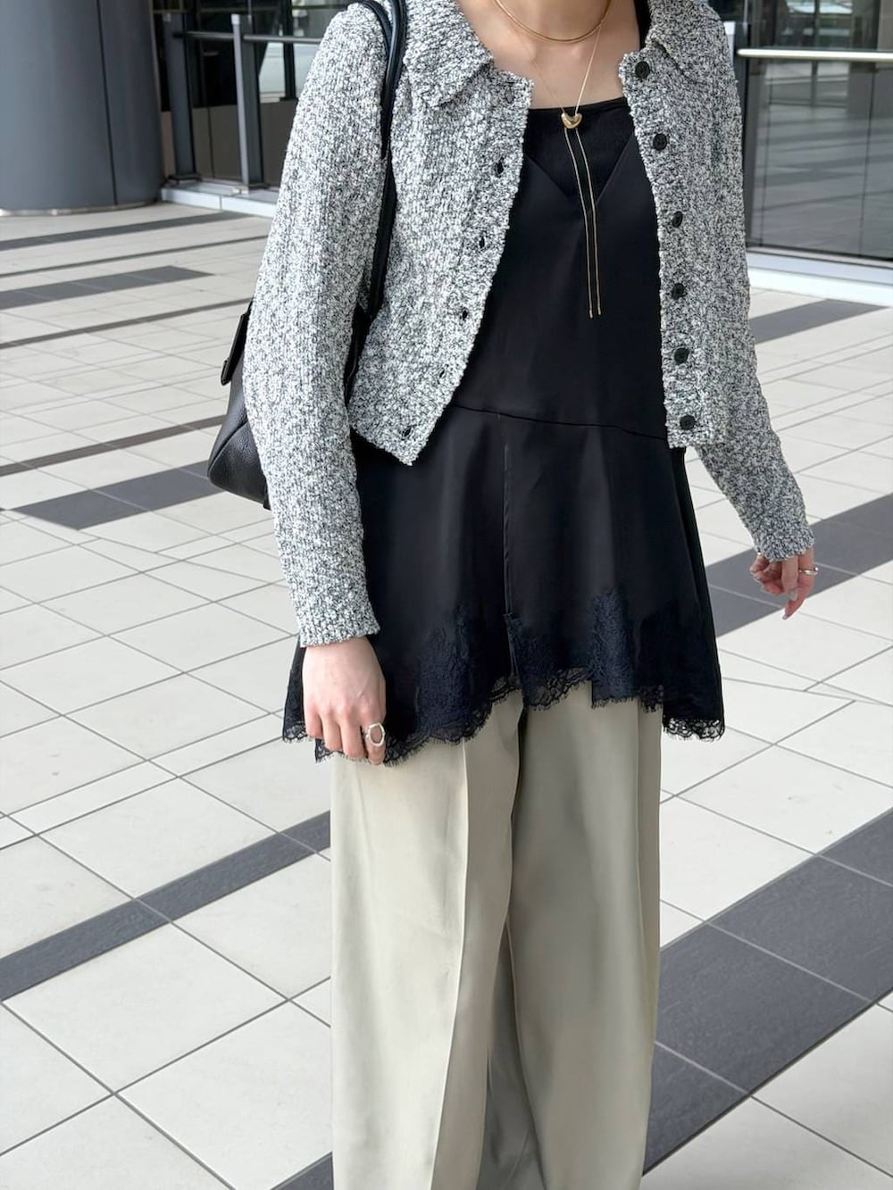 ブラック系のハンドバッグ、ブラック系のサンダル、ブラック系のキャミソールを着用したレディースの春コーディネートの7枚目の写真