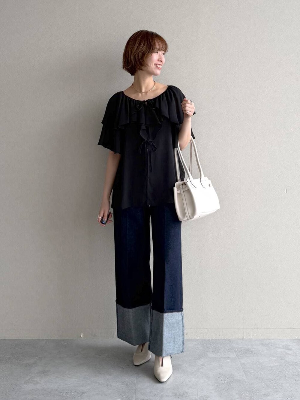 ホワイト系のサンダル、ブルー系のデニムパンツ、ブラック系のシャツ/ブラウスを着用したレディースの春コーディネートの6枚目の写真