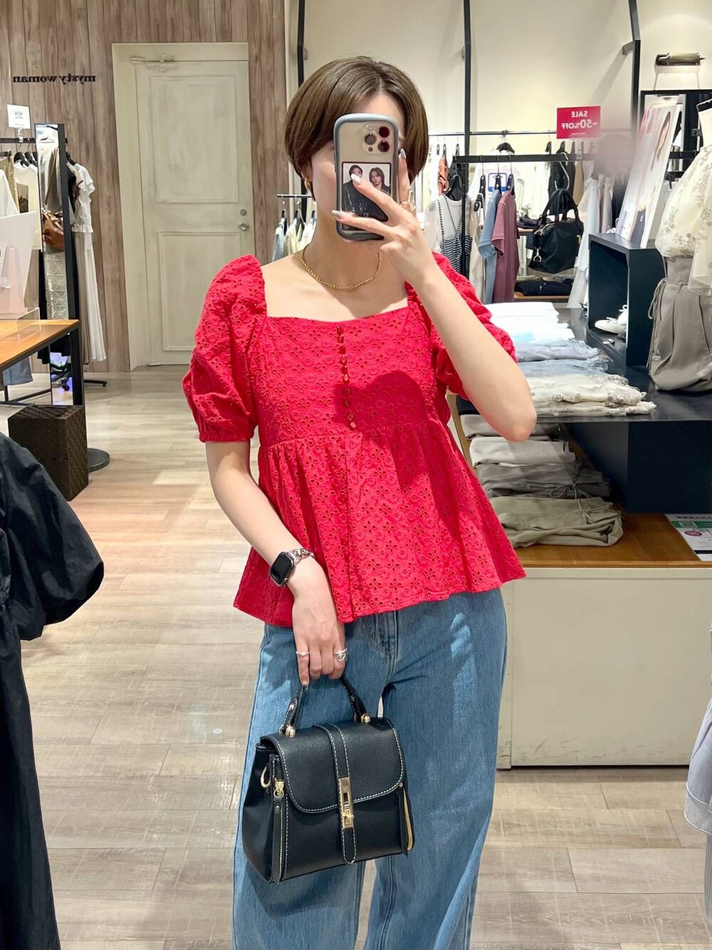 ブルー系のデニムパンツ、ブラック系のサンダル、ブラック系のショルダーバッグを着用したレディースの夏コーディネートの4枚目の写真