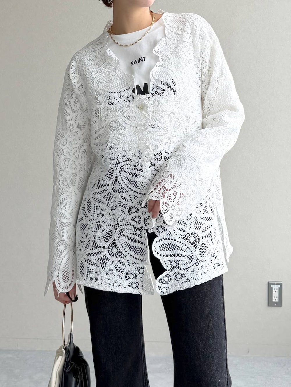 ブラック系のデニムパンツ、ブラック系のサンダル、ブラウン系のブルゾンを着用したレディースの冬コーディネートの8枚目の写真