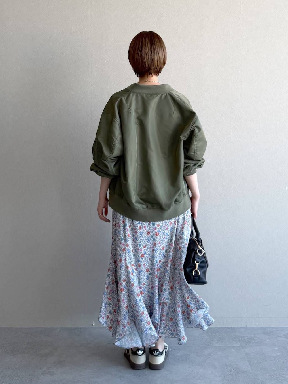 ブラック系のボストンバッグ、ホワイト系のワンピース、グリーン系のMA-1を着用したレディースの冬コーディネートの3枚目の写真