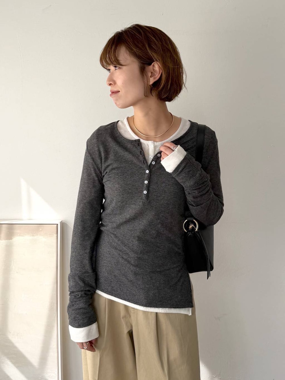 ブラック系のサンダル、ブラック系のショルダーバッグ、ベージュ系のチノパンツを着用したレディースの春コーディネートの3枚目の写真