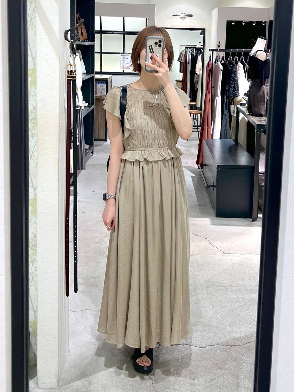 ブラック系のサンダル、ブラック系のショルダーバッグ、ベージュ系のワンピースを着用したレディースの春コーディネートの4枚目の写真